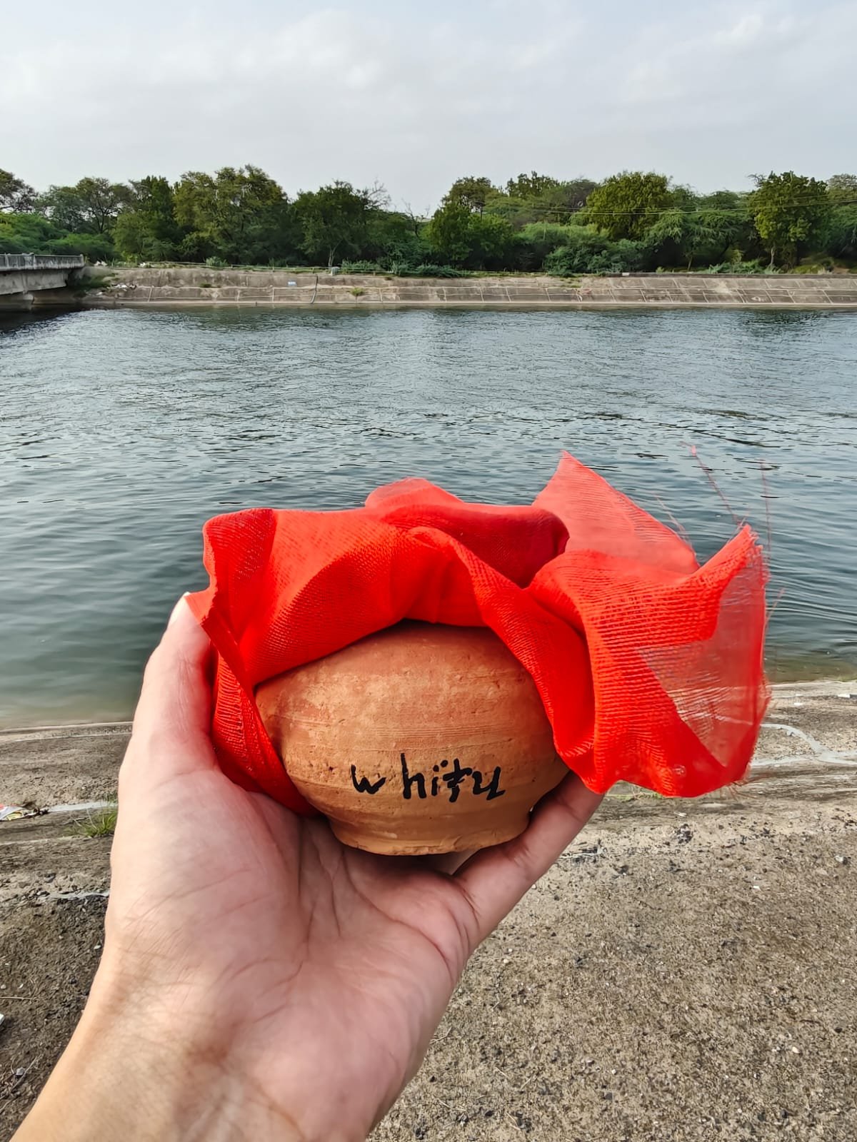 Whitu's ashes in a clay pot by the river